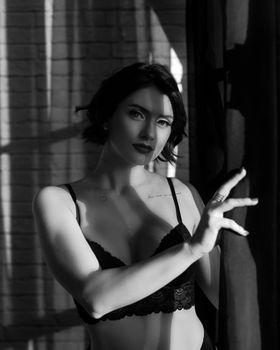 Stunning portrait of a woman in lingerie, captured in striking black and white, evoking elegance and confidence.