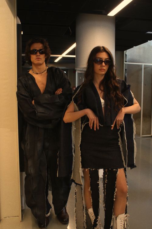 Free Fashionable man and woman in chic outfits posing indoors, showcasing modern styles. Stock Photo