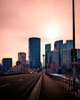 Stunning sunset over Calgary skyline with iconic The Bow building in view.