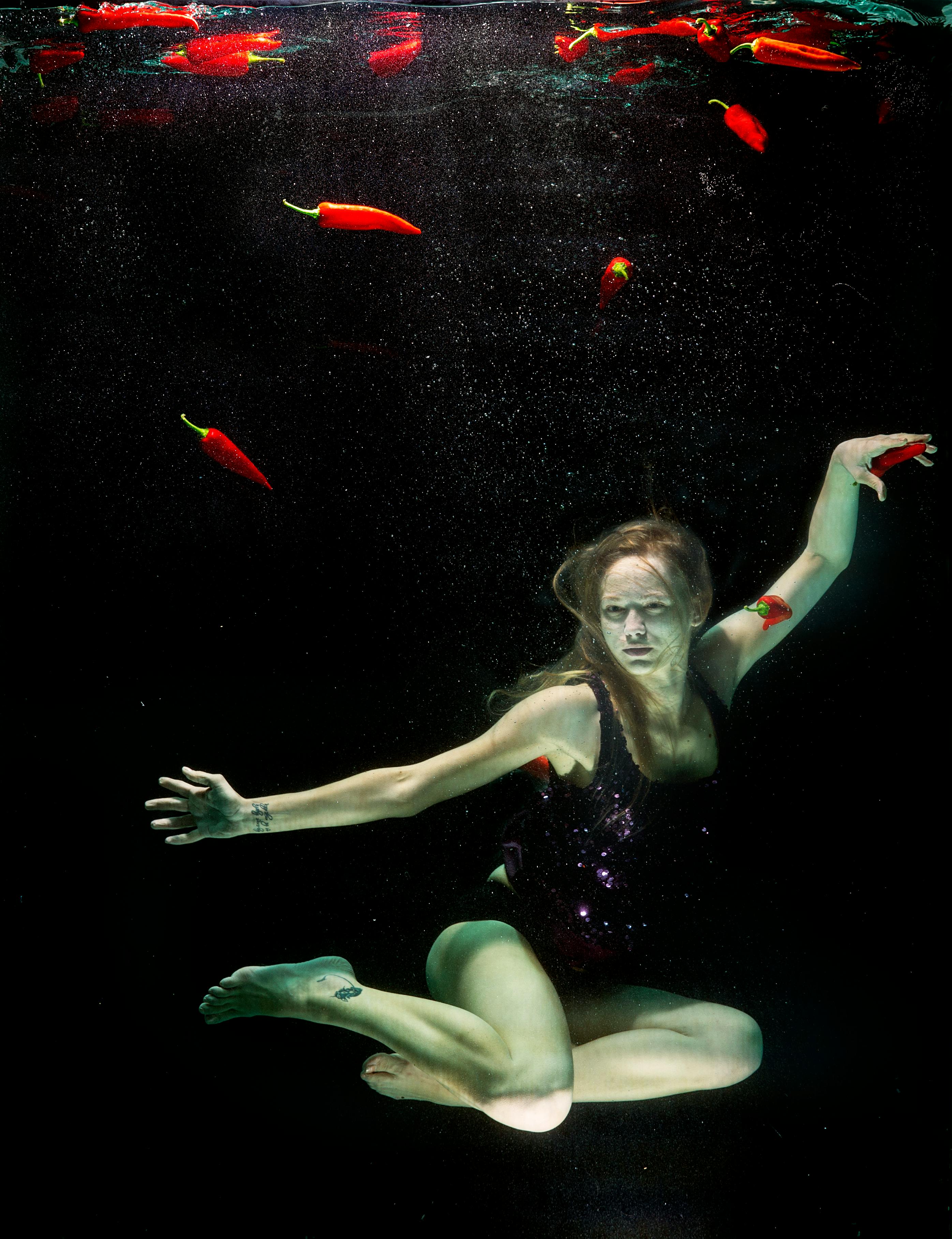 woman underwater wearing black one piece swimsuit