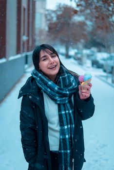 Smiling woman enjoying ice cream on a snowy city street, capturing winter joy.