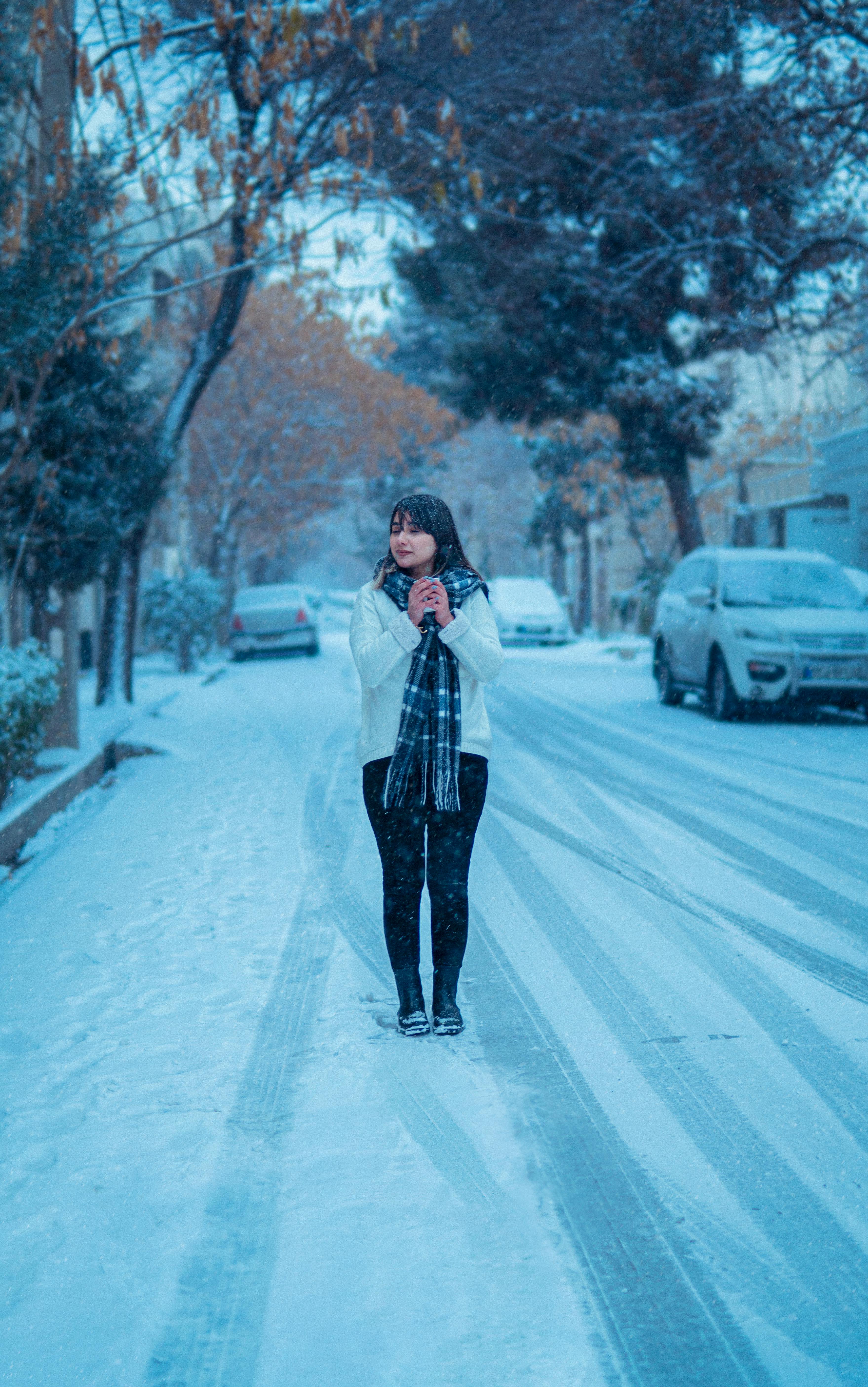 Woman Standing on a Snowy Street in City · Free Stock Photo