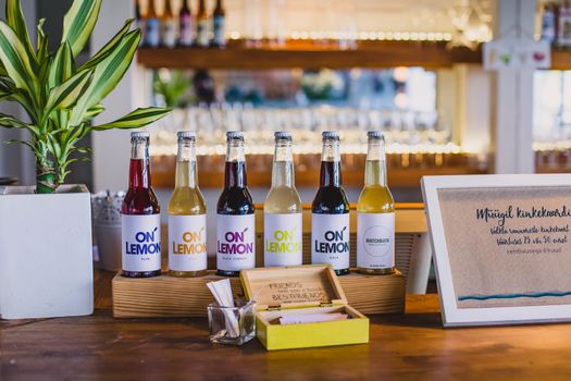 Vibrant bottled beverages arranged on a bar counter with decor.