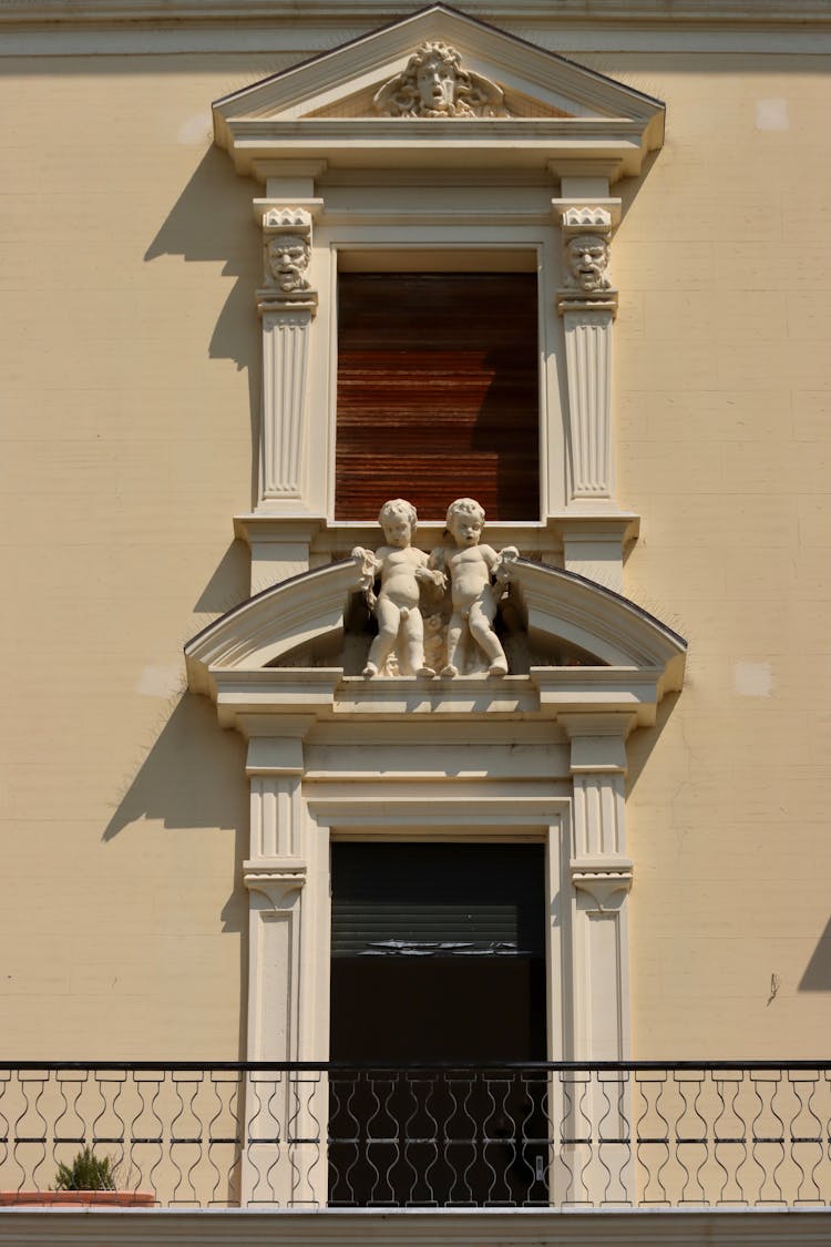 Statue Of Boys Above Window