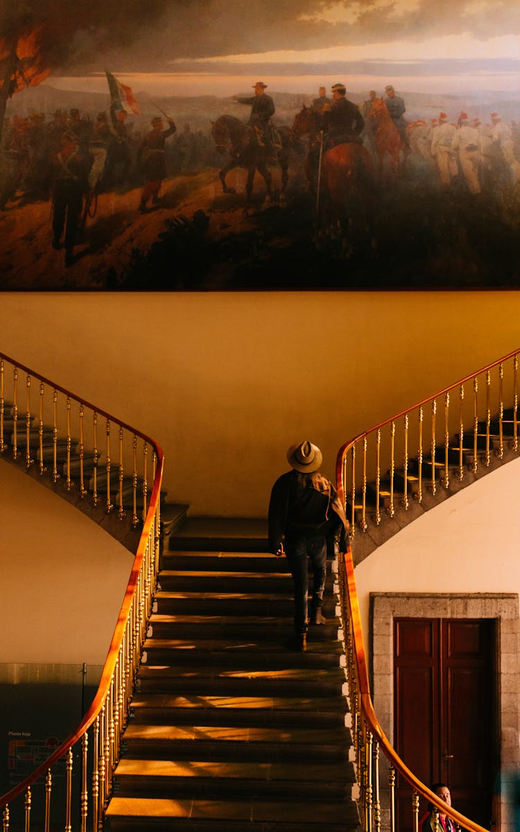 Woman Walking Up The Stairs In A Museum