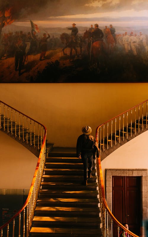 Free Woman Walking Up the Stairs in a Museum Stock Photo
