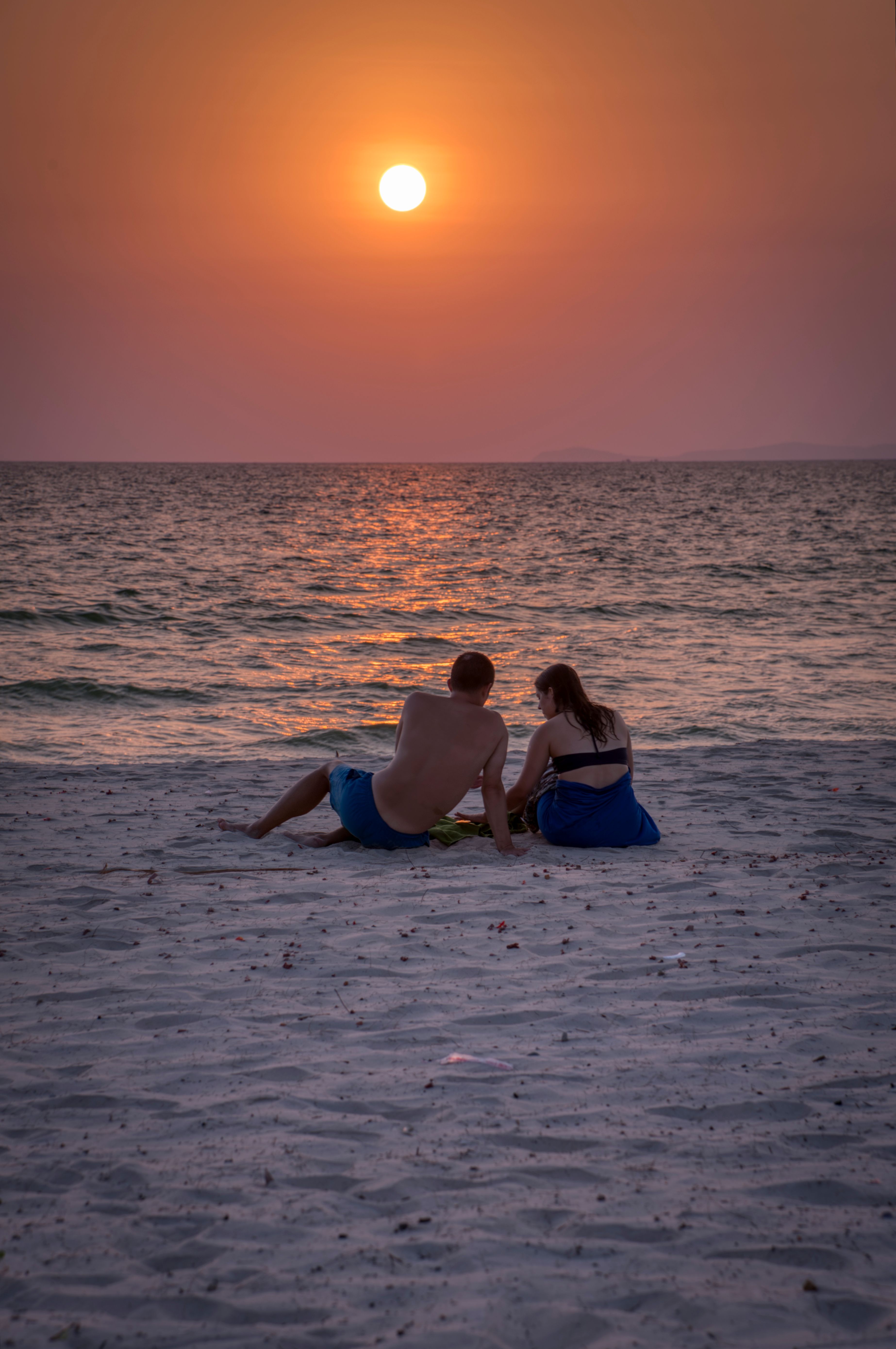 Couple Sitting on Beach at Sunset · Free Stock Photo