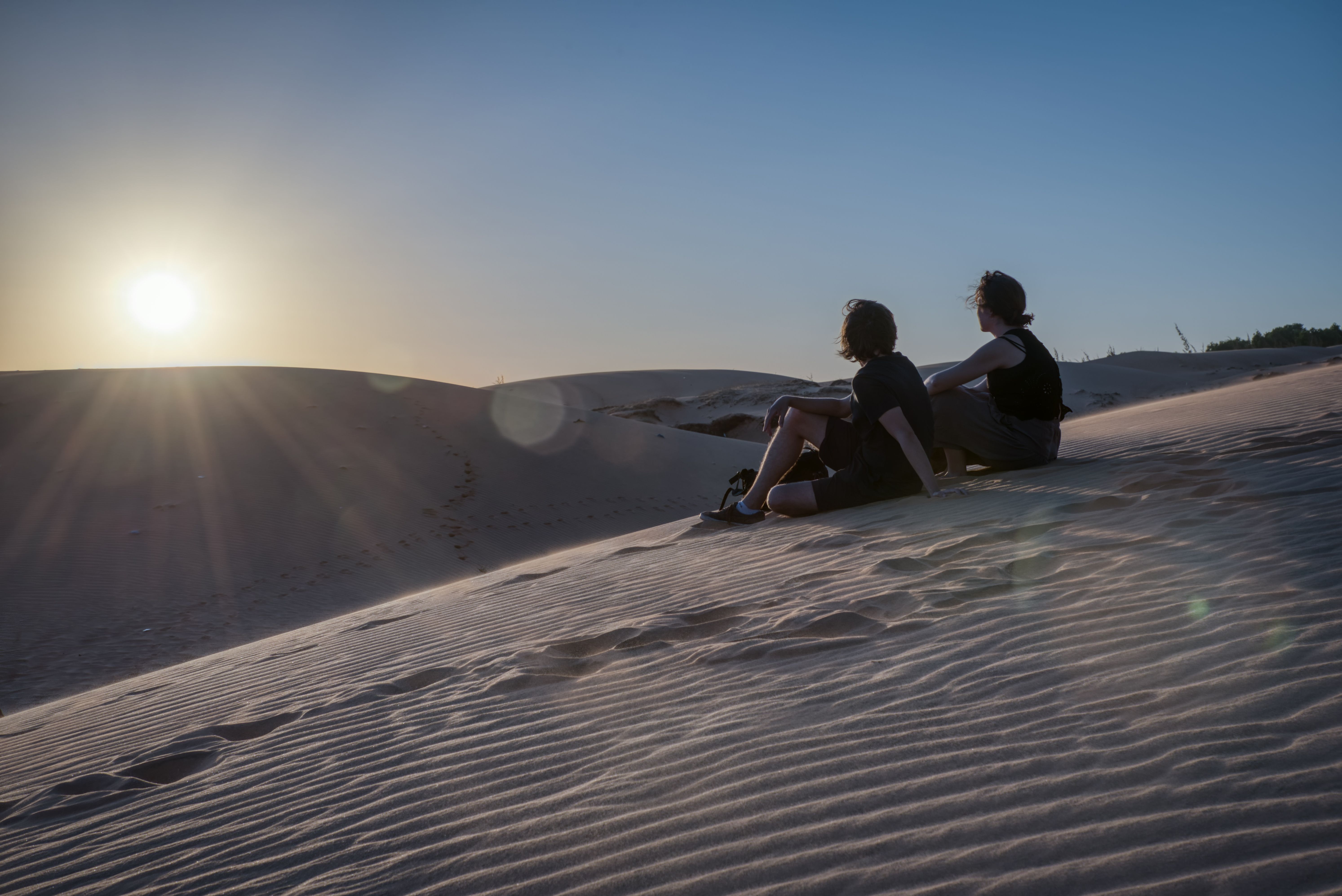 Couple watching the sunset on the dunes