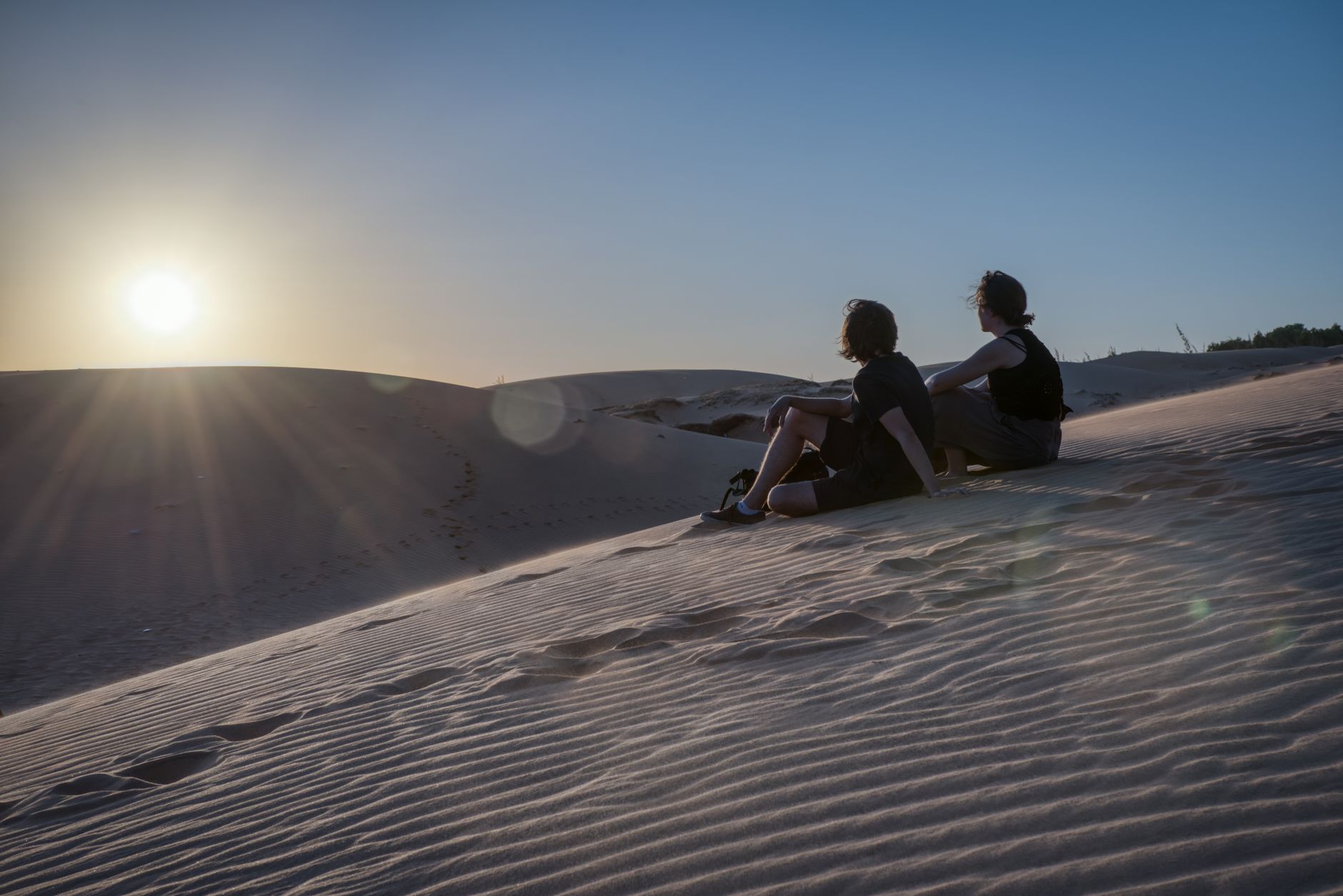 Couple watching the sunset together on the dunes