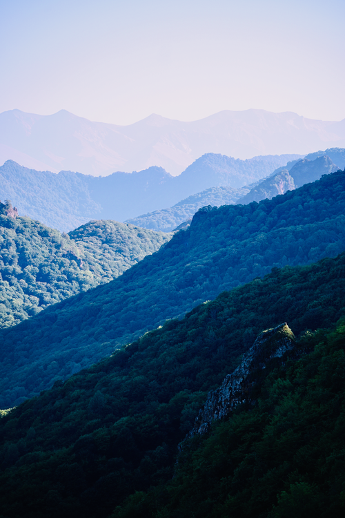 Free Breathtaking view of layered green mountains under the clear blue sky, showcasing natural beauty. Stock Photo