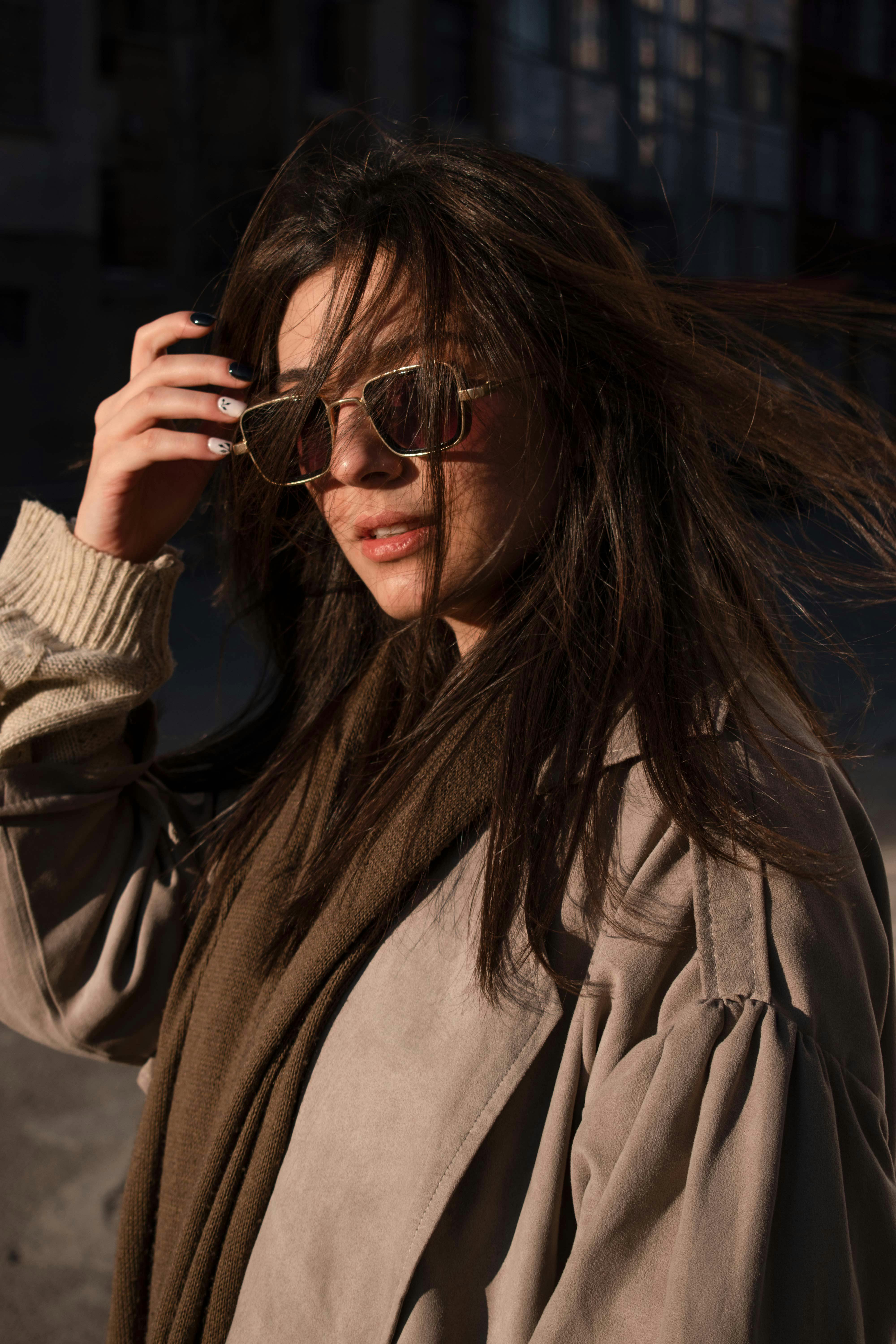 a woman in sunglasses and a trench coat