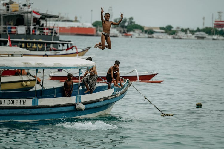 Boys Jumping From Boat Into Water