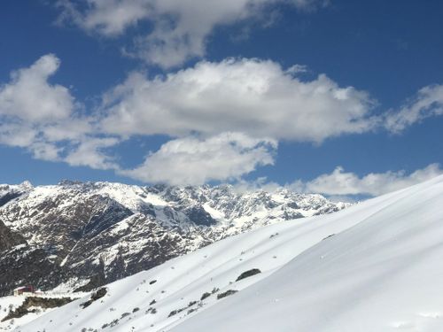 Free Breathtaking snowy mountains under a clear blue sky with clouds. Stock Photo