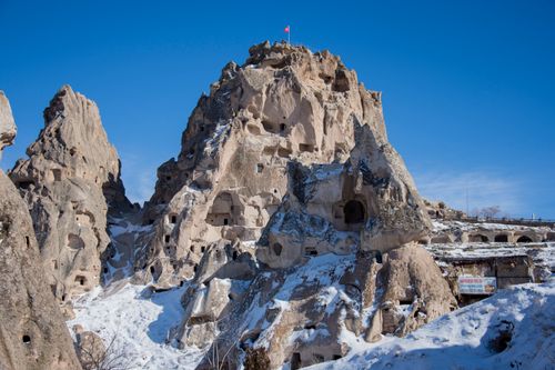 Free Explore the stunning snow-covered rock formations and blue skies of Cappadocia, Turkey. Stock Photo