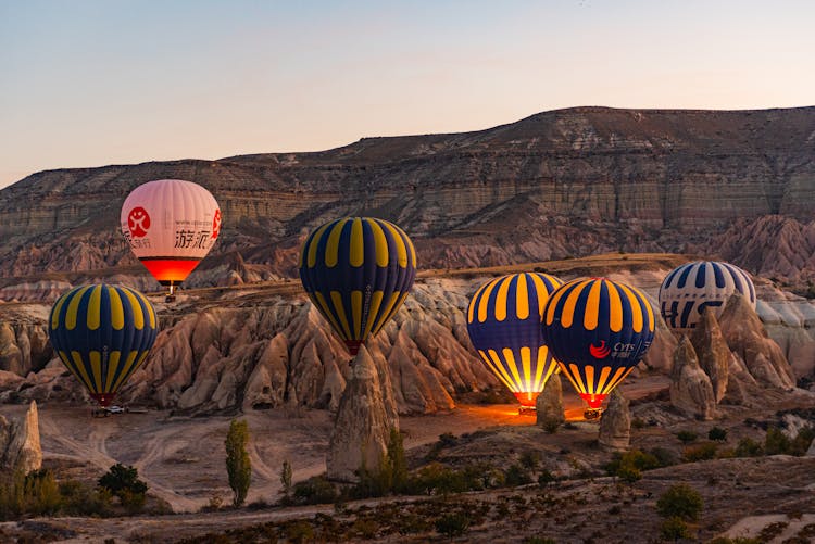 Hot Air Balloons Flying In Mountains Landscape On Sunset