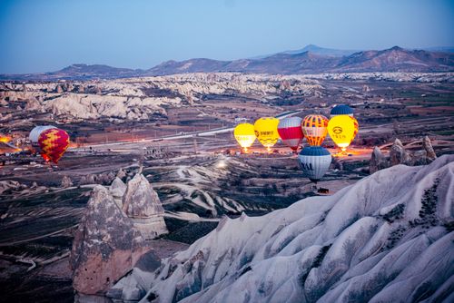 Free A breathtaking view of hot air balloons soaring over the unique rock formations of Cappadocia at sunrise. Stock Photo
