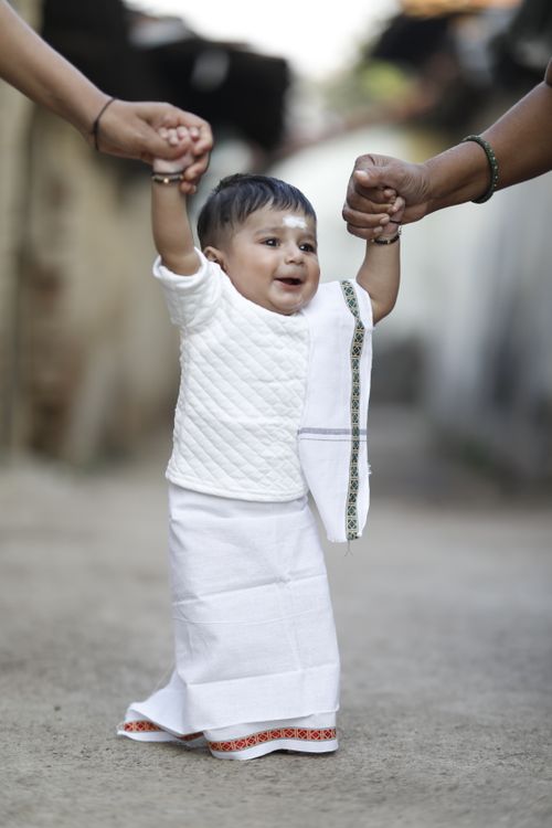 Free Cute baby in traditional clothing holding hands with adults, outdoors. Stock Photo