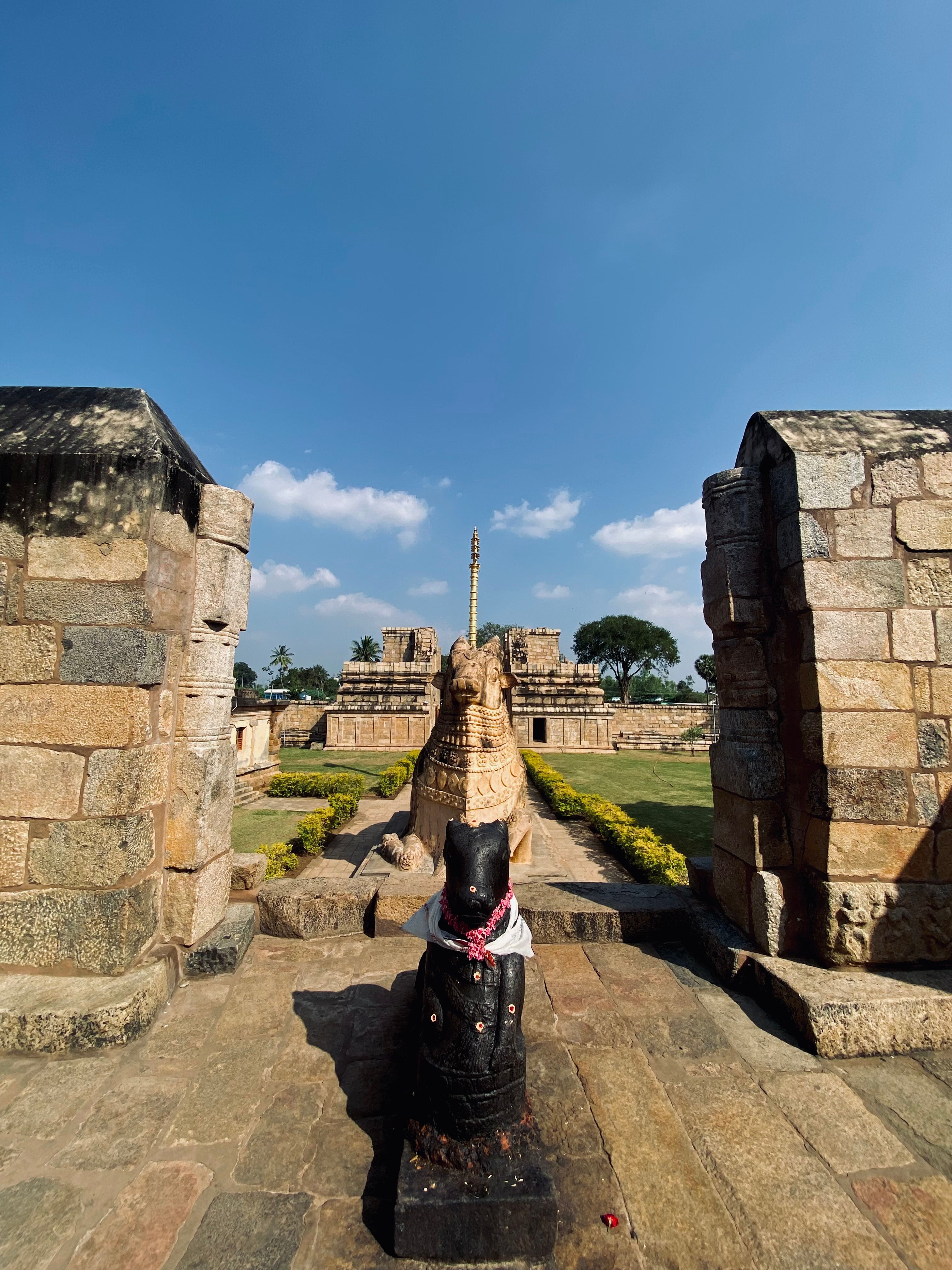 Explore the ancient temple ruins with intricate stone sculptures in Thanjavur, India under a clear sky.