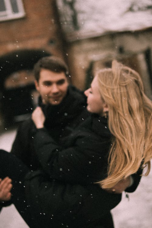 Man Holding Woman in Snow