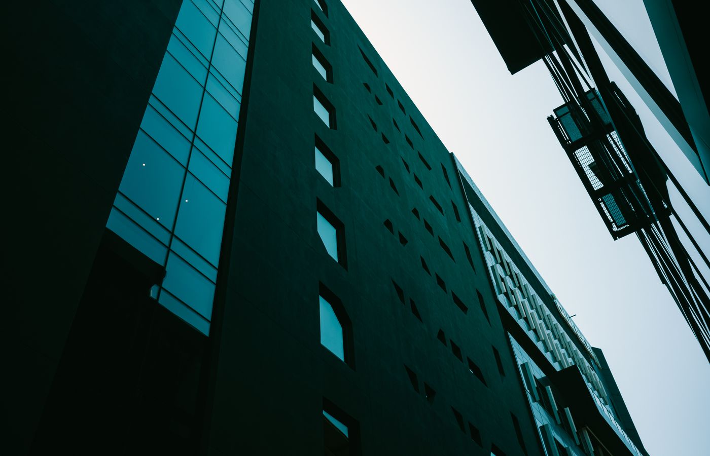 Low angle view of modern buildings with overcast sky and distinctive architecture.