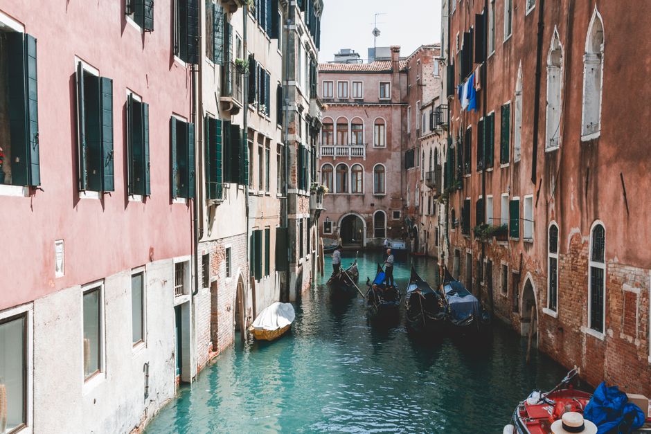 Picturesque view of gondolas navigating a narrow canal in Venice's historic district.