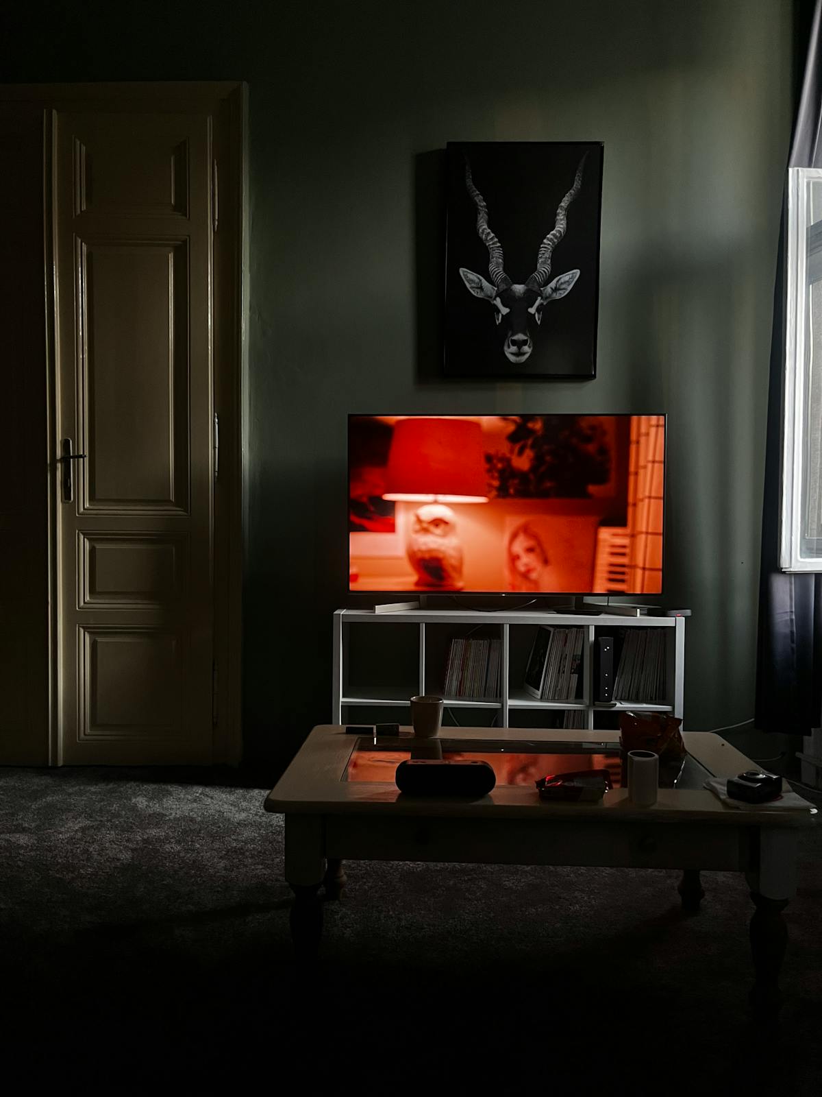 Televisore acceso in soggiorno con interfaccia app e profili visibili