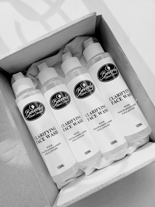 Grayscale Photo of Facial Wash Products in the Box