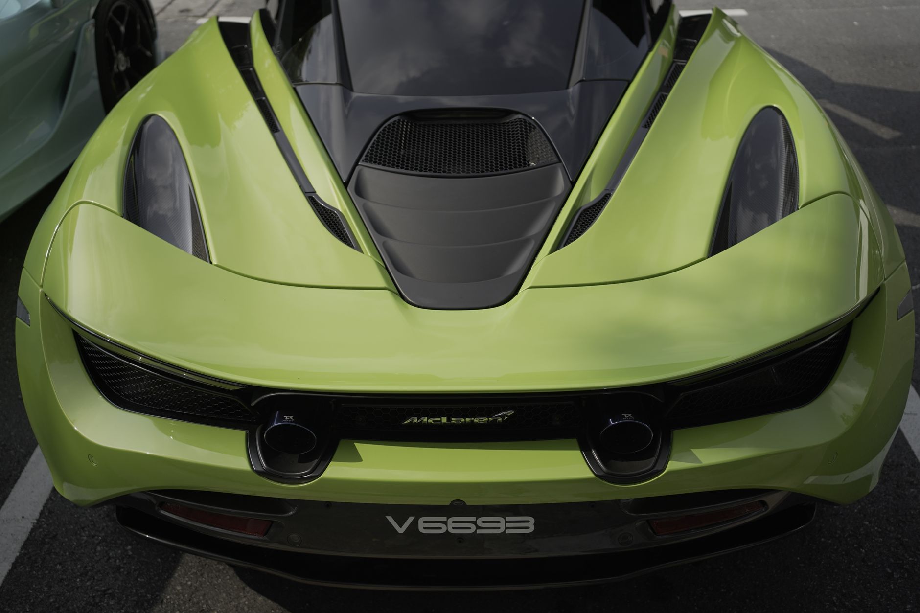 Close-up of a sleek green McLaren sports car showcasing its aerodynamic design.