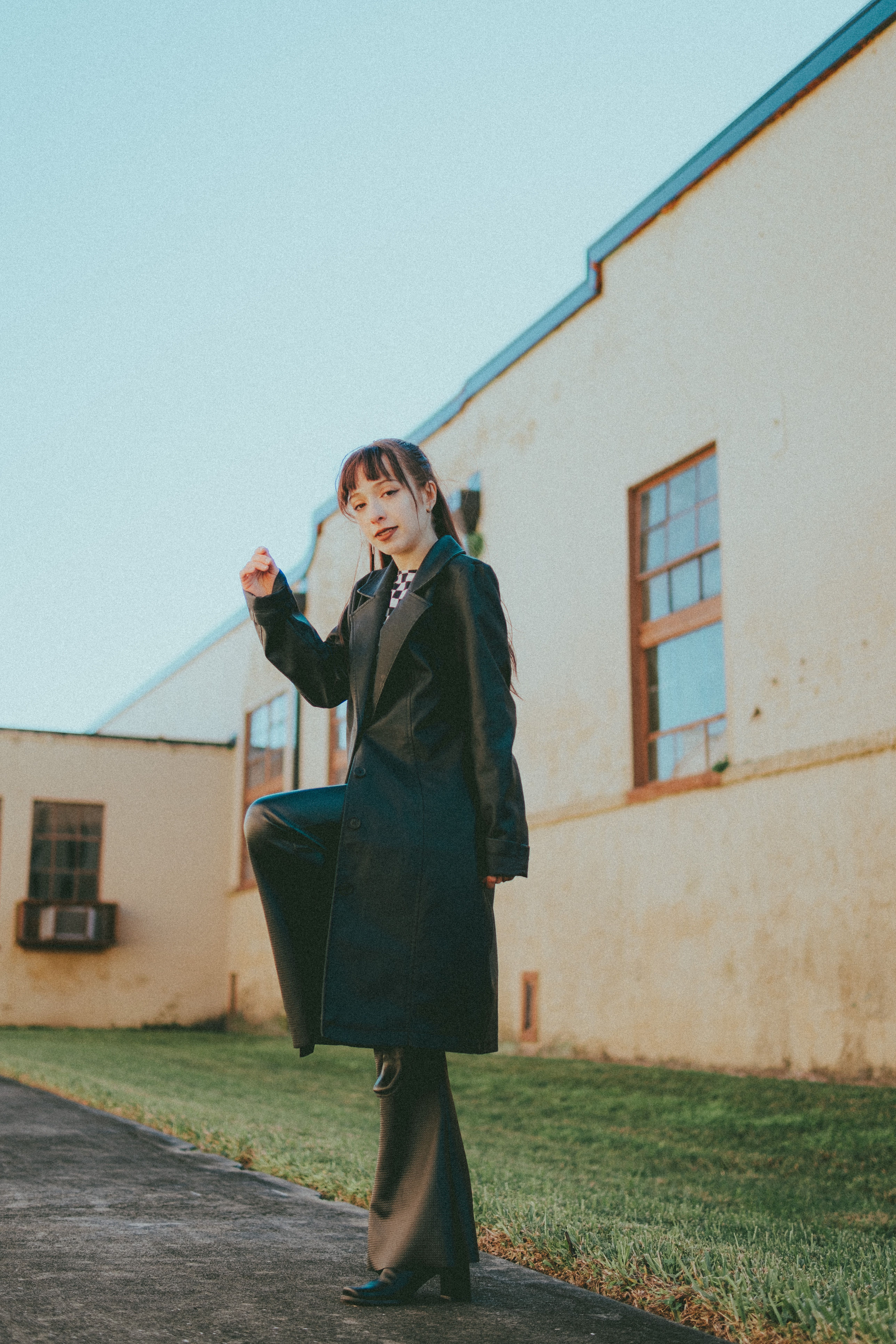 Young Woman in a Black Coat Standing on One Leg · Free Stock Photo