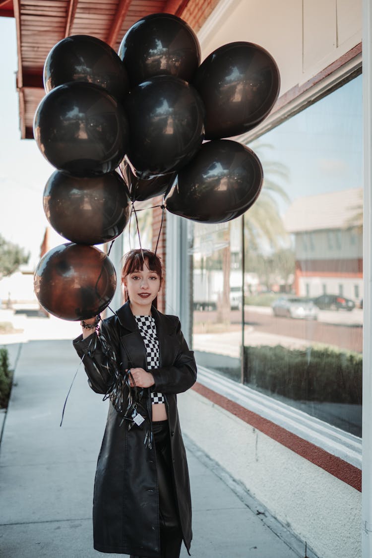 Woman Holding Black Baloons