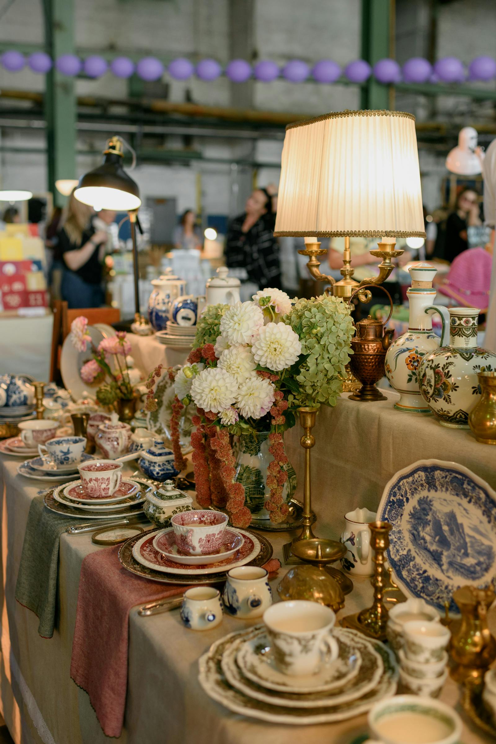 Pottery and lamps at an indoor antique fair