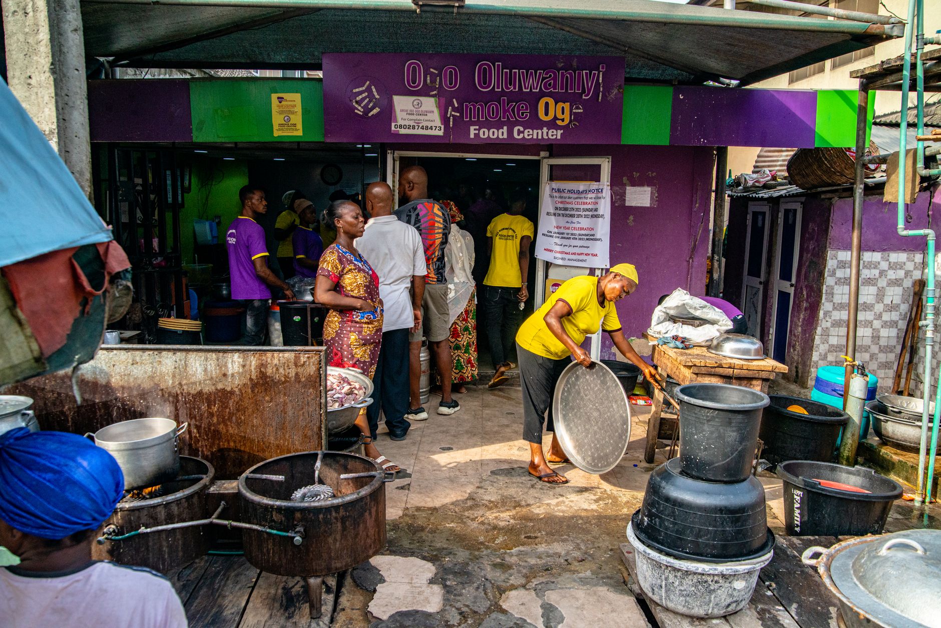 Outdoor scene of people at a local food center, bustling with activity and vibrant colors.