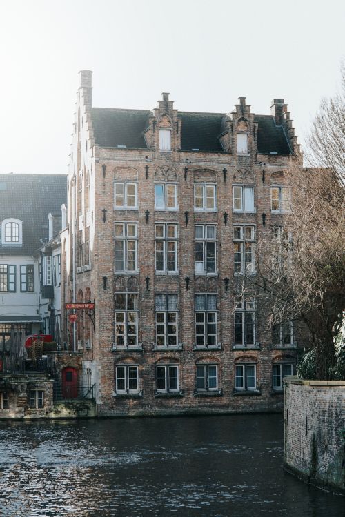 Free Historic building by a canal in Bruges, Belgium, with classic architecture under daylight. Stock Photo