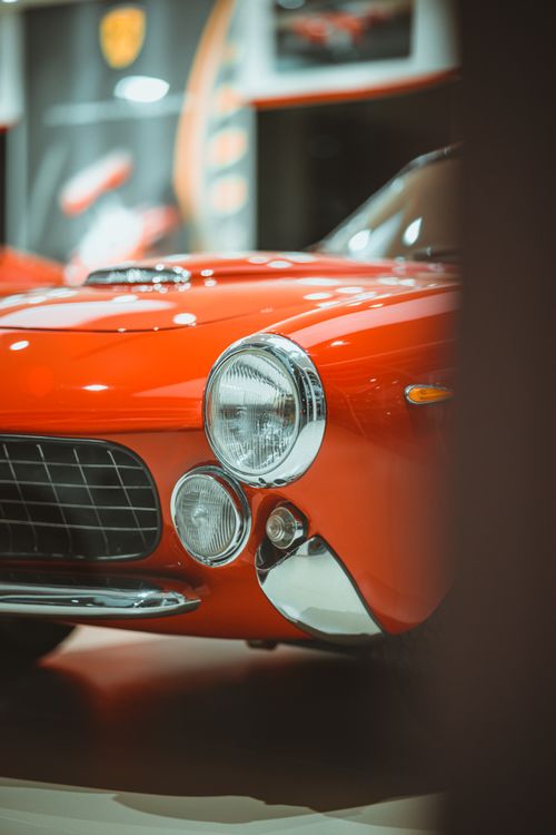 Free A detailed shot of a classic red vintage car showcasing its luxurious design and headlights. Stock Photo