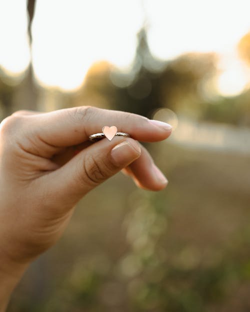 Close-up of Woman Holding a Ring with a Heart 