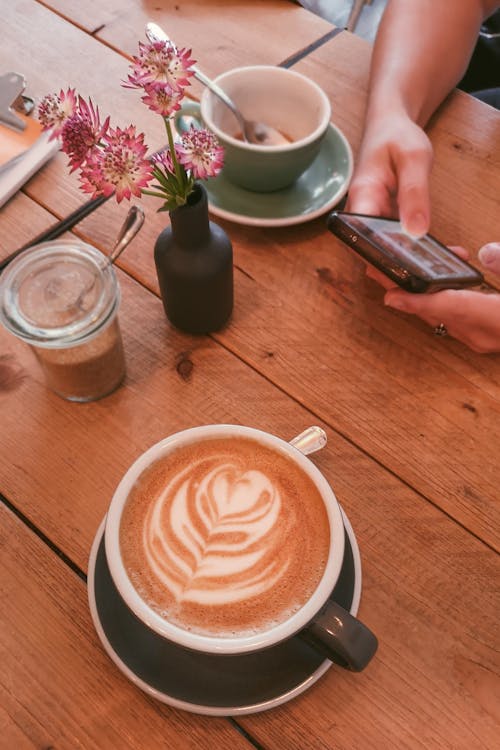 Coffee on Table, Person Hands Holding Smartphone