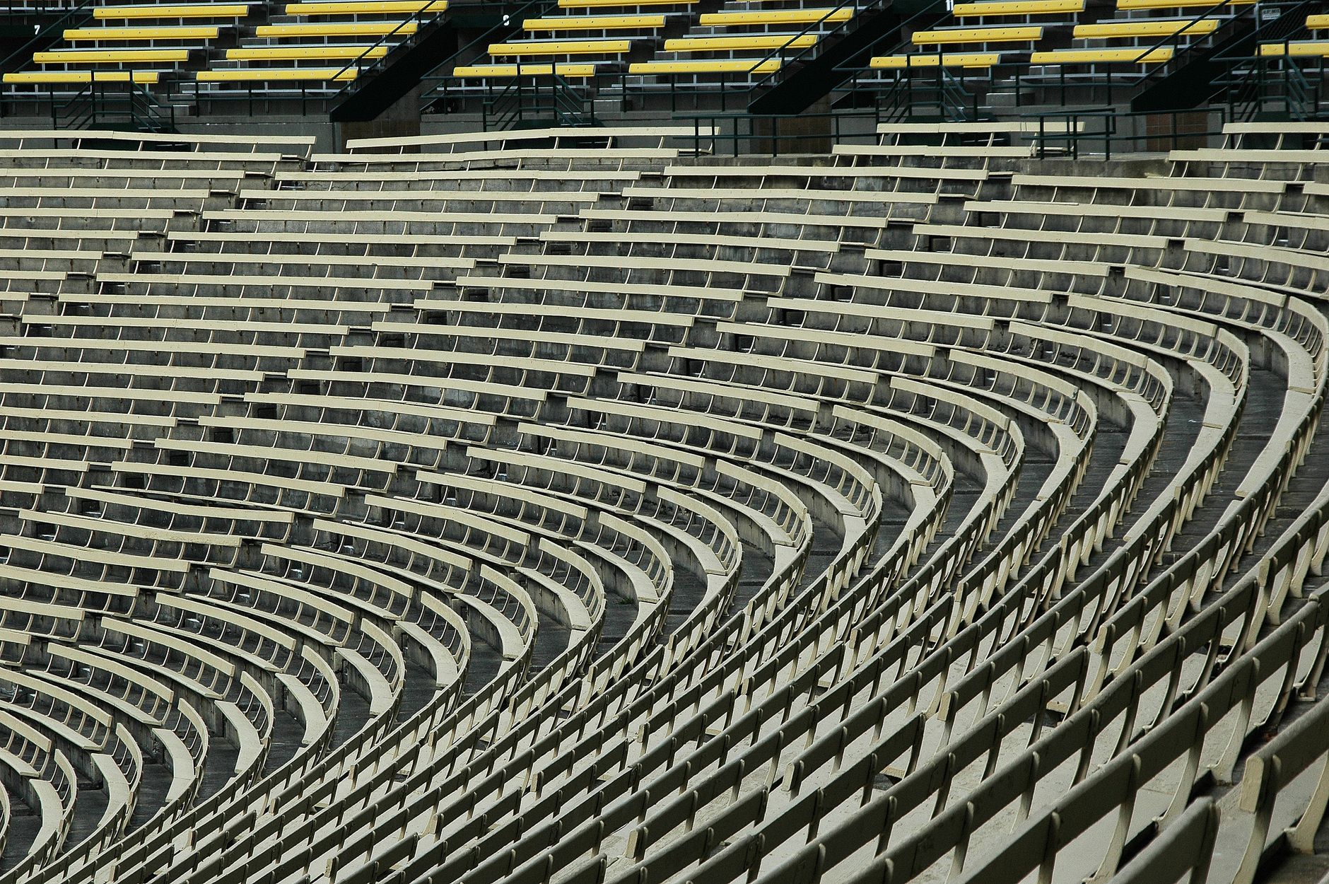 Lambeau Field stands covered in snow as Green Bay supporters hold team flags during an afternoon NFL game