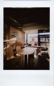 Warm and inviting empty cafe interior with natural light creating a cozy ambiance.