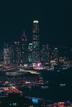Vibrant night view of Hong Kong's illuminated skyline with skyscrapers and harbor.