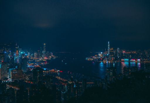 A stunning view of Hong Kong's illuminated skyline with reflections on the harbor at night.