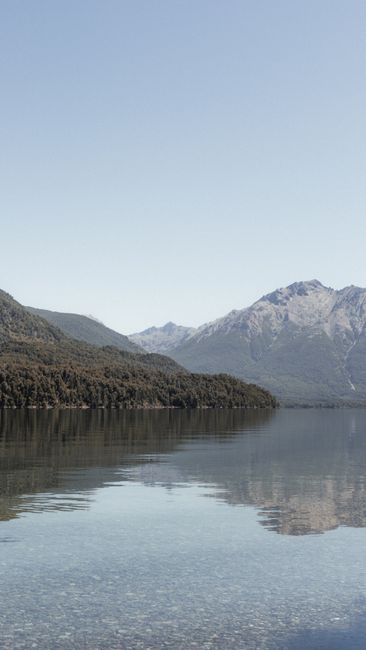 Peaceful lake scene with mountains reflecting in water in Bariloche, Argentina.