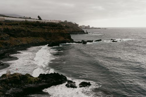 Free A scenic view of coastal cliffs and waves under a cloudy sky, capturing nature's beauty. Stock Photo