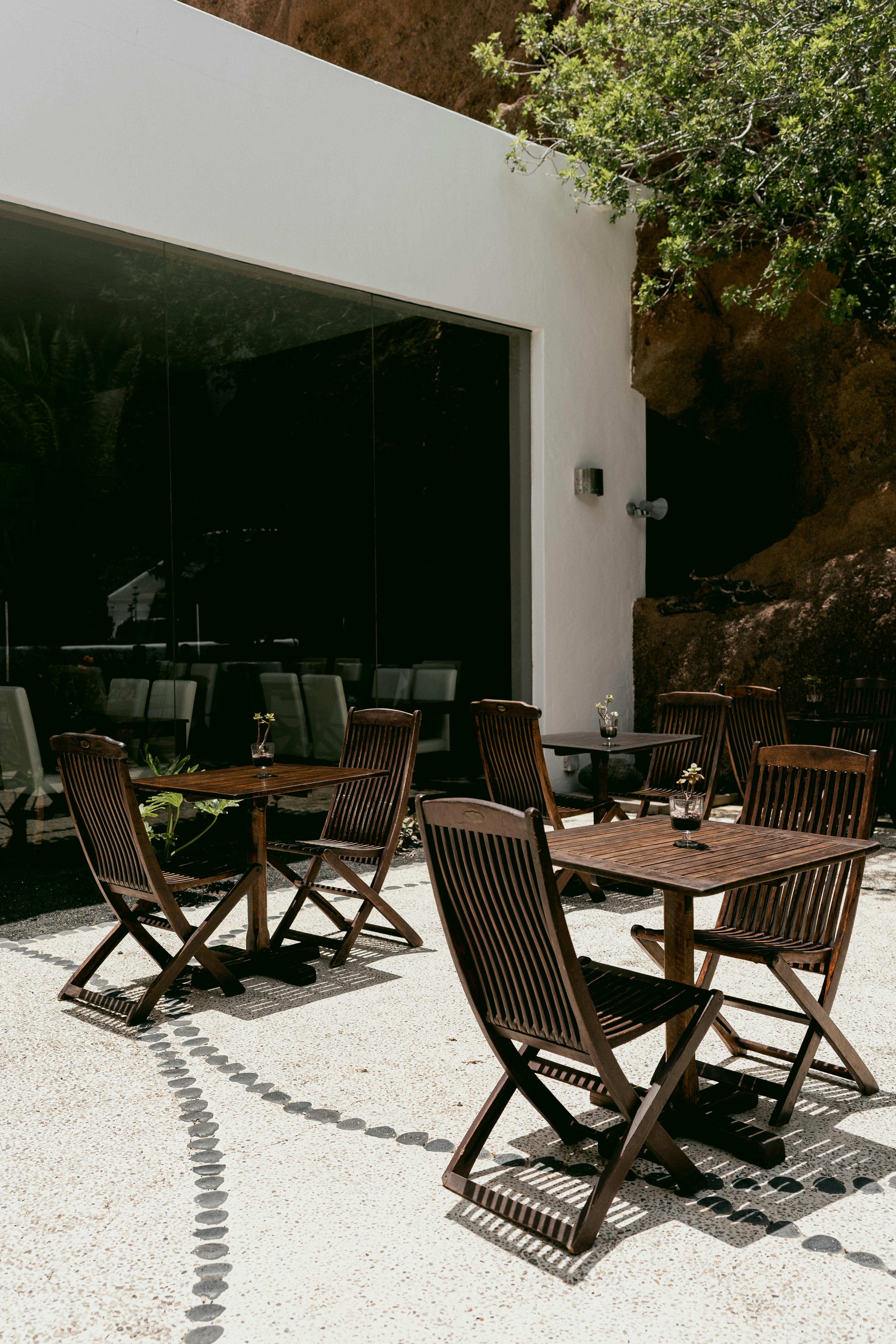 Elegant outdoor wooden furniture set on a sunny patio, perfect for relaxation.