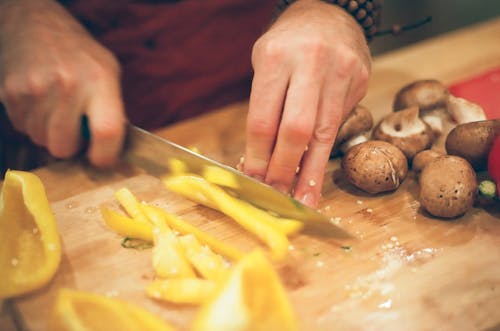 Person Slicing Peppers and Mushrooms
