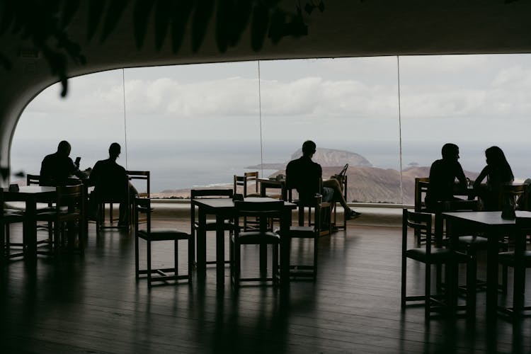 Silhouette Of People In A Restaurant With An Ocean View