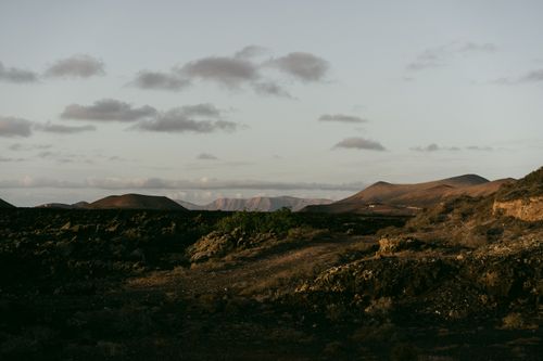 Free Peaceful arid landscape with hills and mountains under a dramatic sunrise sky. Stock Photo