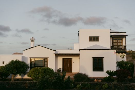 Elegant white villa with modern architectural design surrounded by lush greenery.