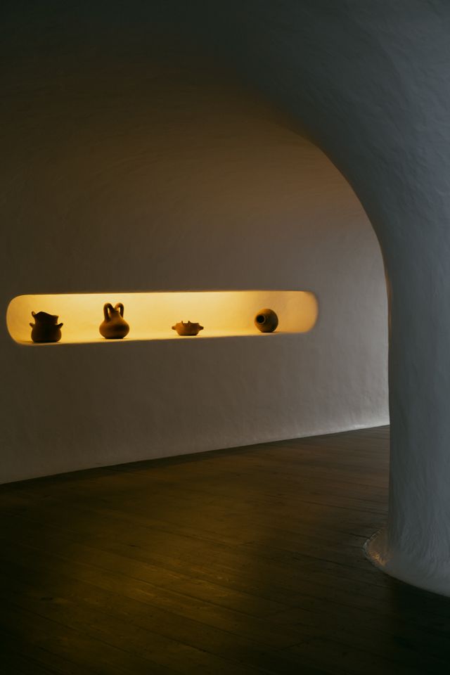 Estanteria curva con ceramica artesanal e iluminacion suave
