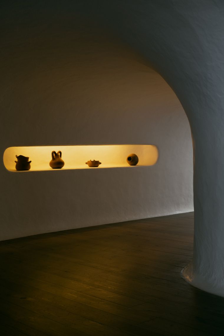 Estanteria curva con ceramica artesanal e iluminacion suave