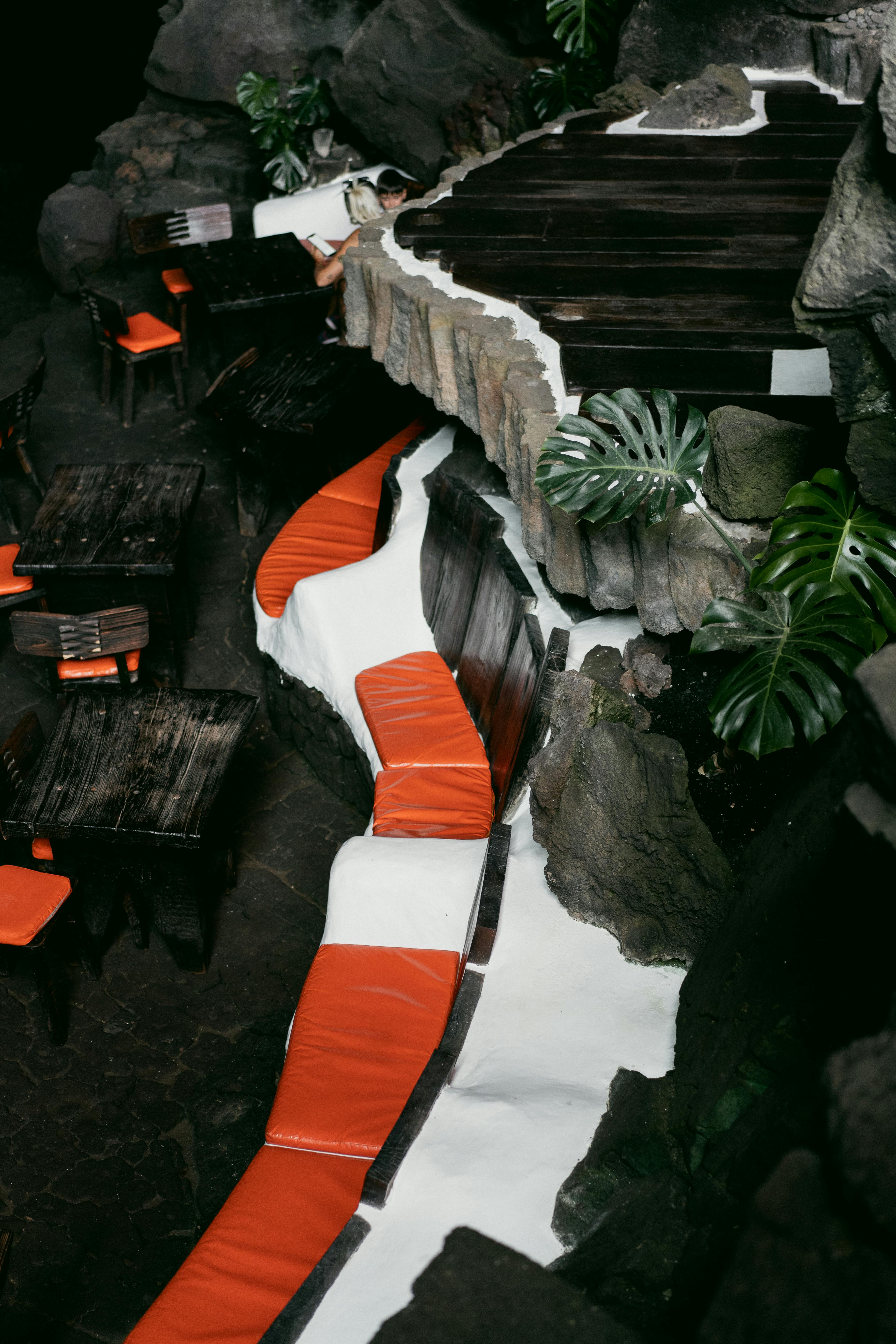 Intriguing cave-like restaurant interior with stone walls and vibrant seating.